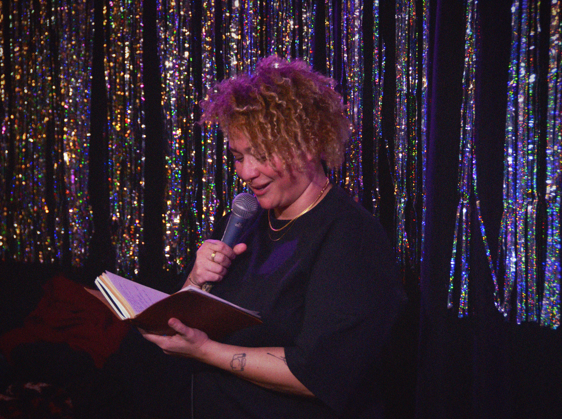 person reading from a book and talking on the microphone