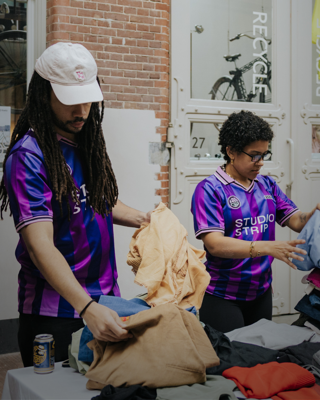 two people displaying clothes on a table